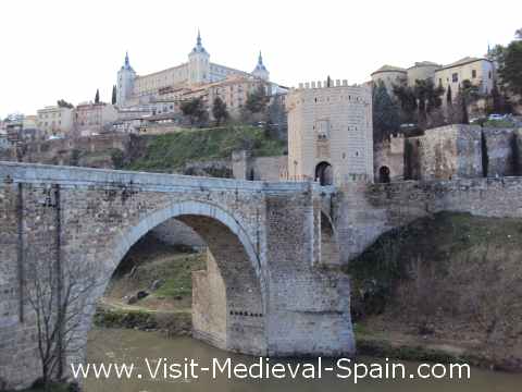 The Puente de Alcantara bridge over the river Tajo with the Alcazar and the old town of Toledo in the background.